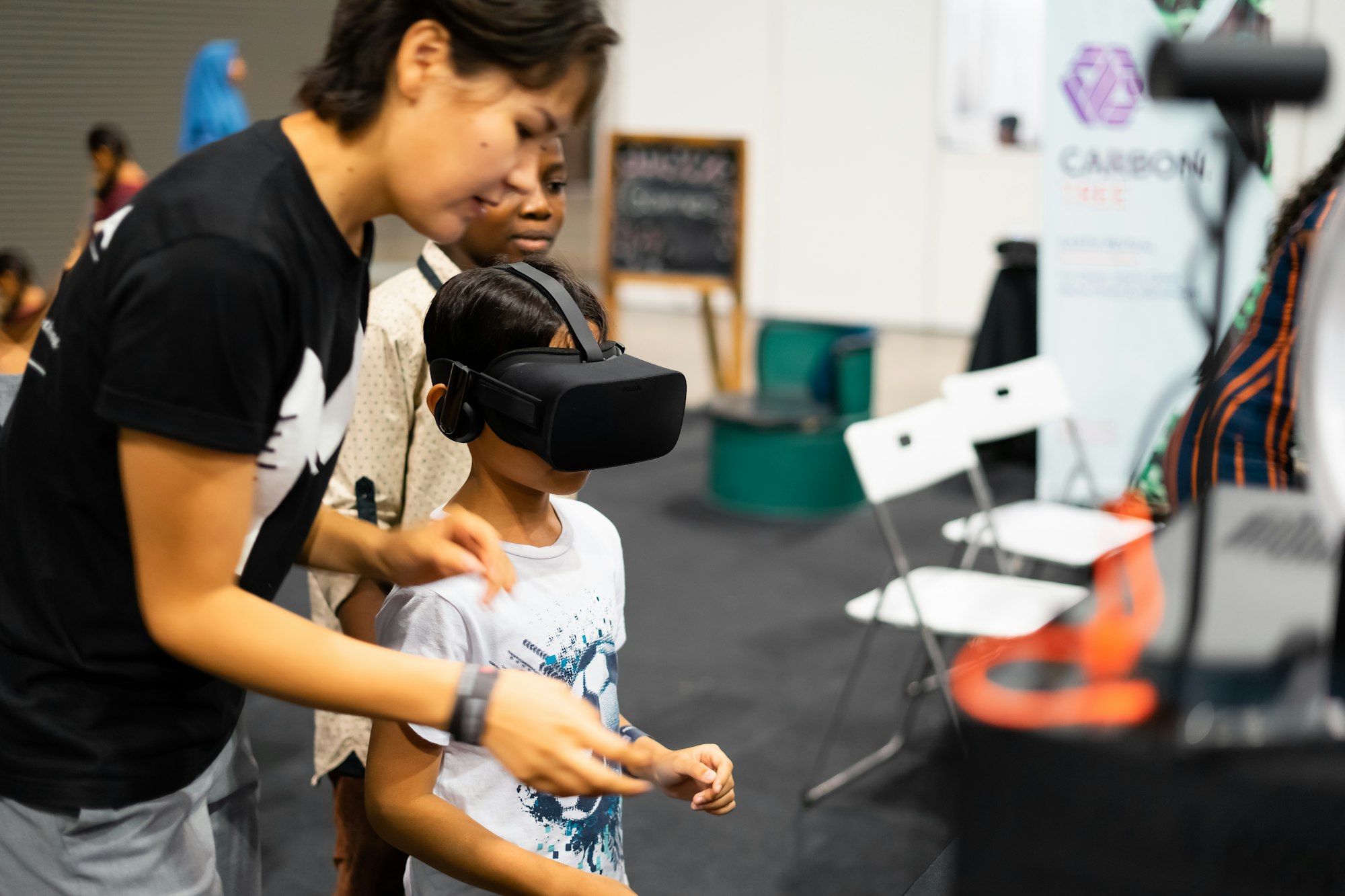 young-boy-using-virtual-reality-gear-with-adult-at-the-digital-fair.jpg